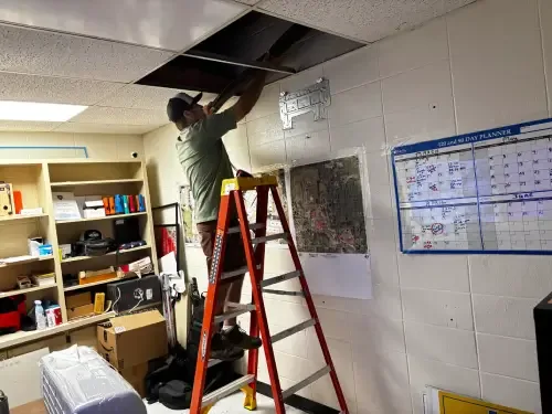 HVAC technician inspecting ductwork in an attic